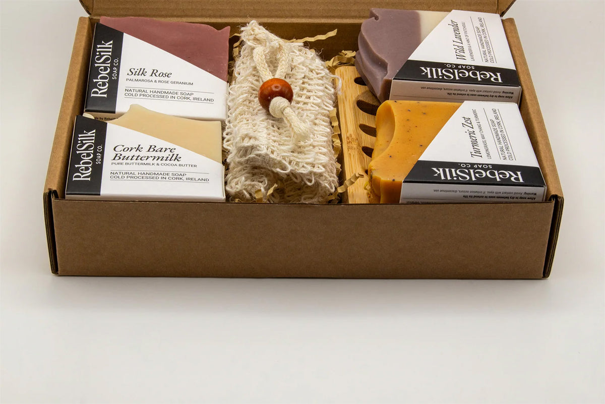 Box of RebelliSilk products including silk ribbons and a hair tie on a white background